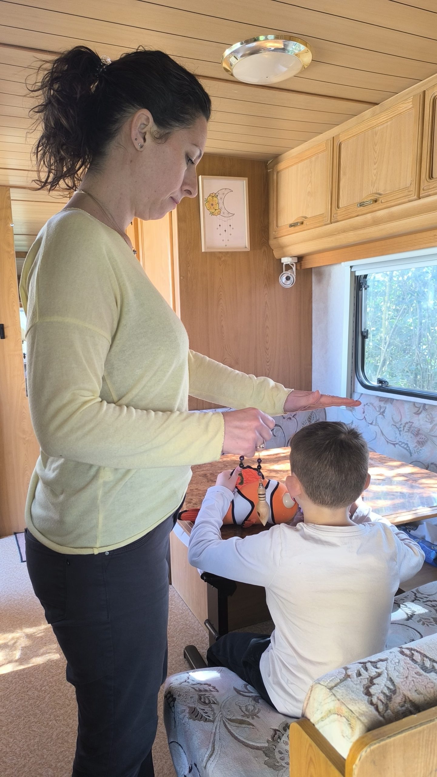 Julie Rimbault réalisant une séance de soin énergétique sur un enfant dans sa caravane à Saint-Rémy, près de Bourg-en-Bresse.
